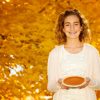 Girl with braces holding a pie on Thanksgiving.