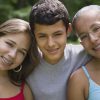Family of three siblings smiling with braces on